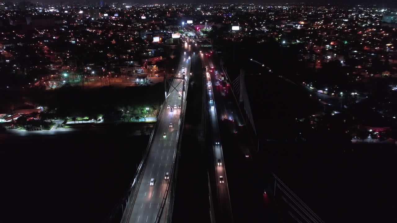 Low speed aerial view over Juan Pablo Duarte and Juan Boch Bridge at night, Santo Domingo