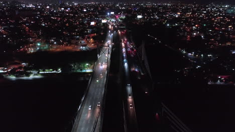 low speed aerial view over juan pablo duarte and juan boch bridge at night, santo domingo