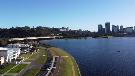 Drone-Aerial-View-of-South-Perth-foreshore-along-Swan-River-and-cycle-path-with-Narrows-Bridge,-Kings-Park-and-Skyline