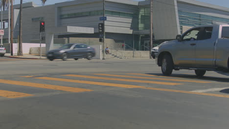 circa 2022s august, los angeles, united states: cars crossing the green light and zebra crossing stripes