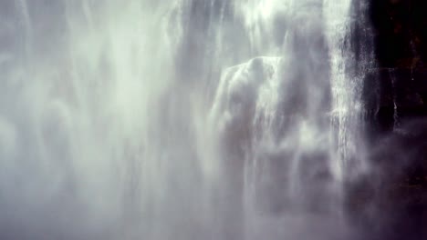 sheets of water and mist splashing down the mountain in the form of a powerful waterfall