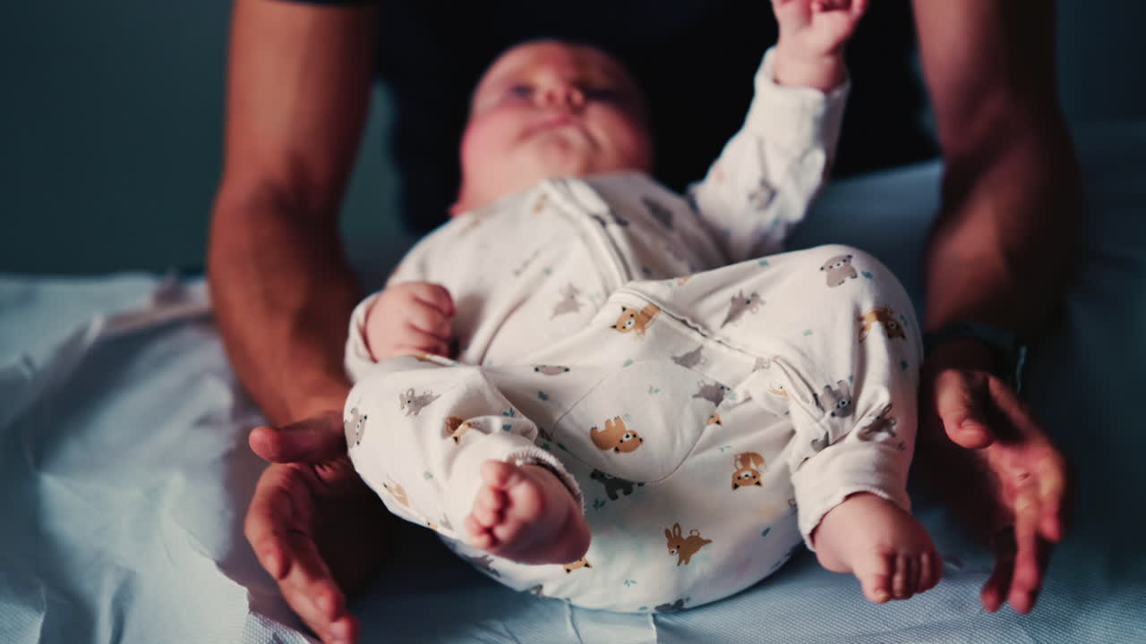 Neonato cullato delicatamente da un* caregiver durante una sessione pediatrica