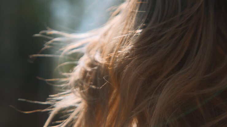 Blond haar van een vrouw in de wind