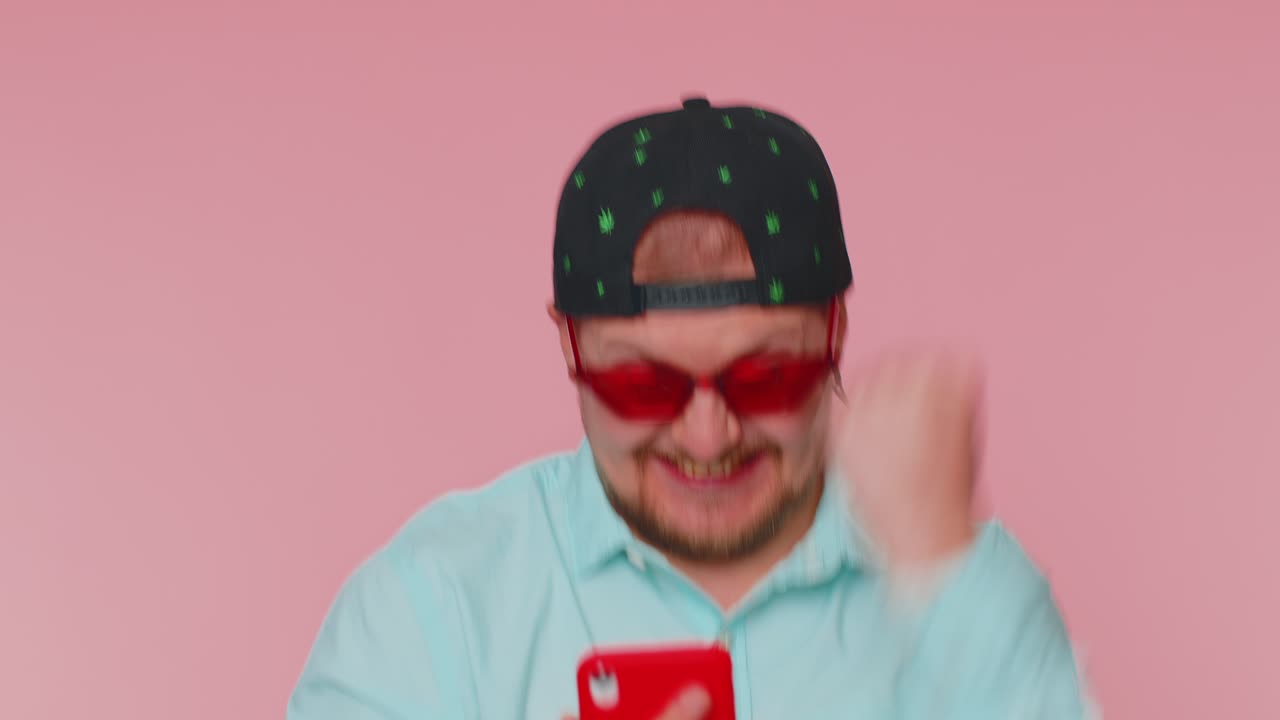 L'uomo felice e eccitato usa il cellulare per dire wow sì ha scoperto una grande notizia di vittoria facendo il gesto del vincitore