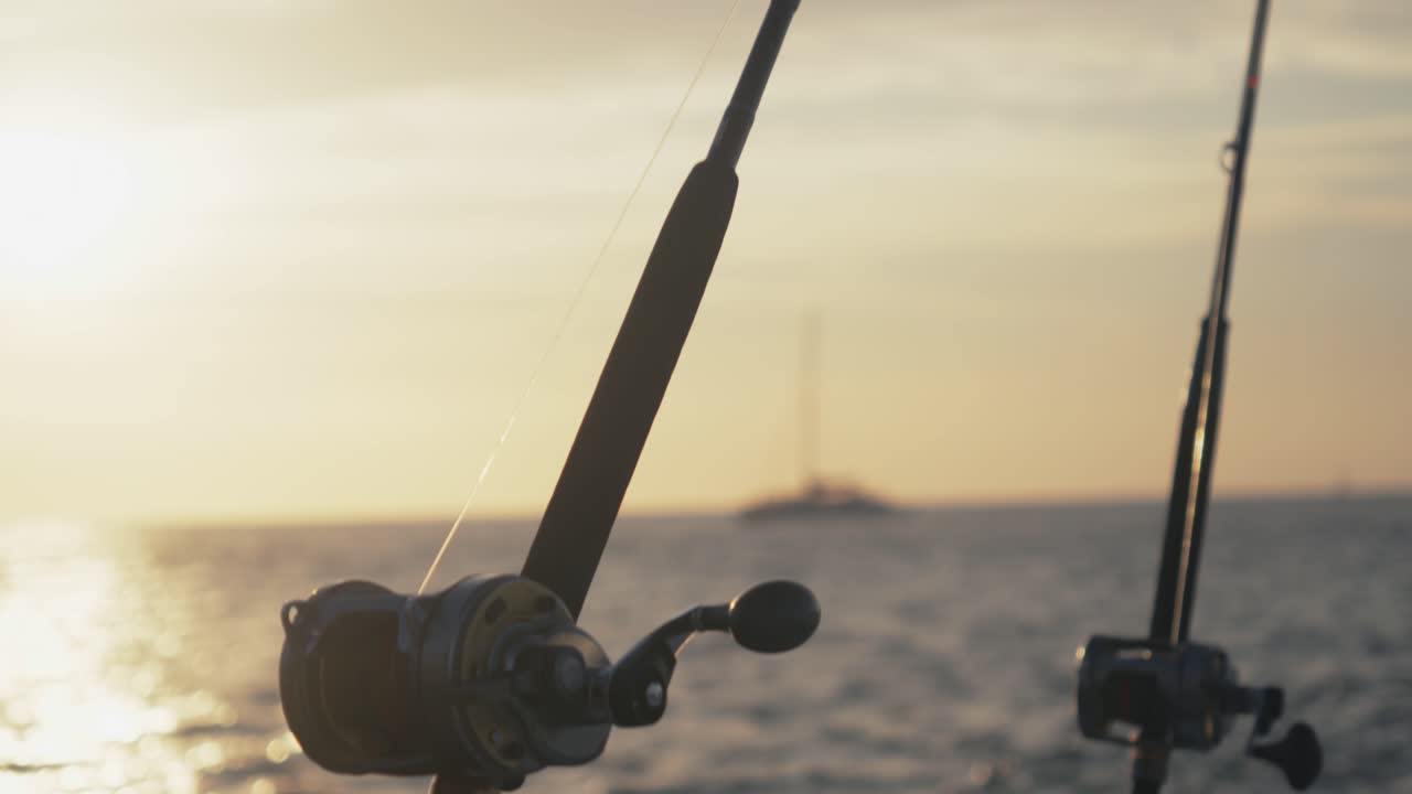 La telecamera panoramica dalla punta di una canna da pesca al mulinello montato su una barca durante l'ora d'oro