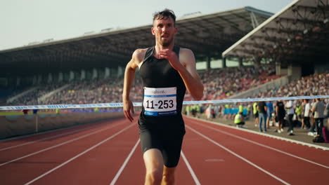 male runner crosses the finish line at a track and field event
