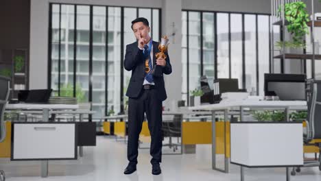businessman holding a trophy in a modern office