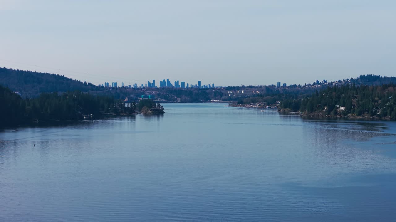 A scenic aerial drone shot of the Indian arm river with a view of Burnaby over the horizon