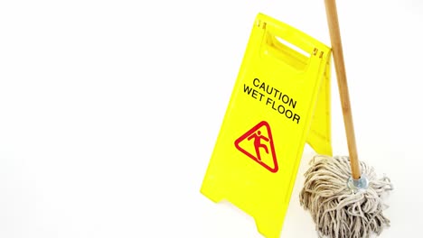 mop with wet floor caution sign