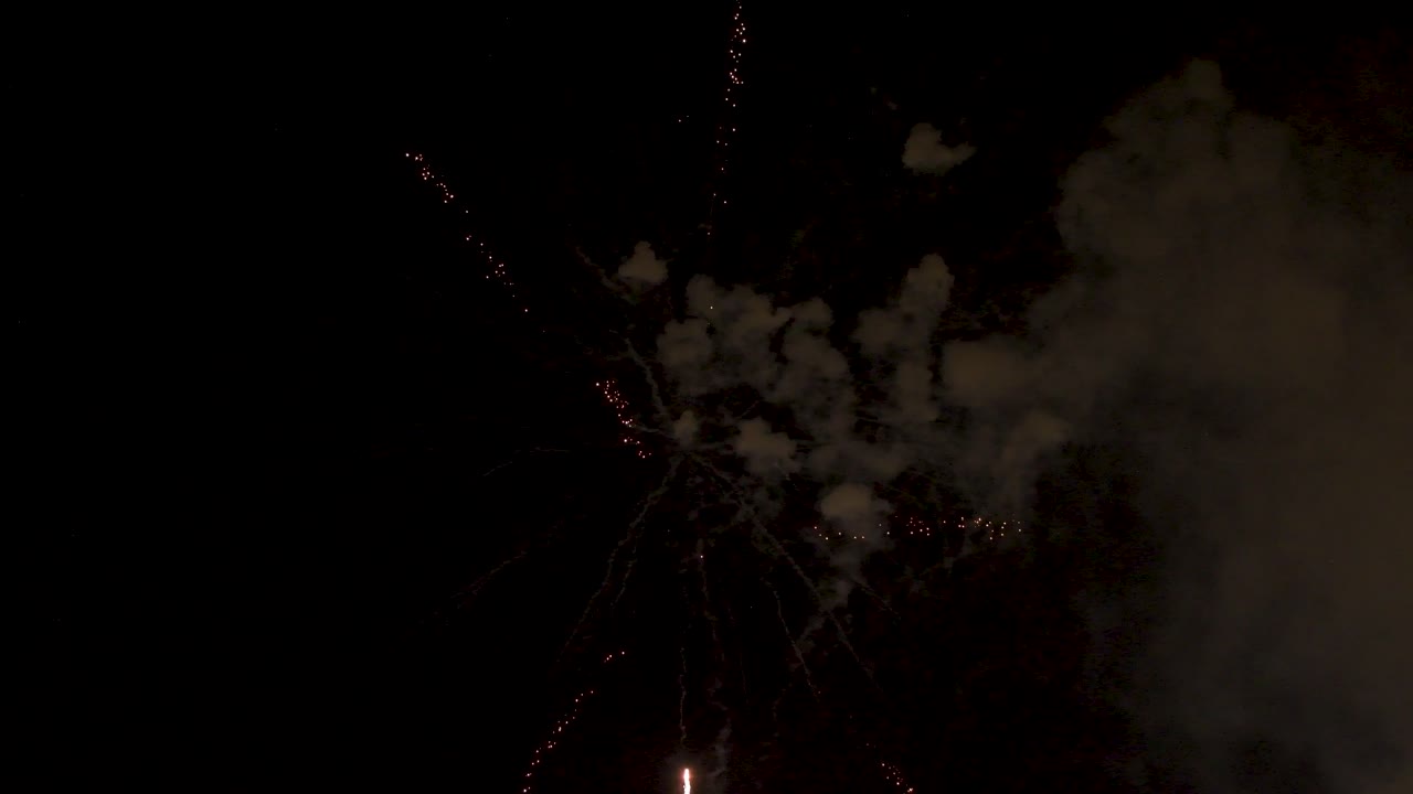 los fuegos artificiales explotan dejando un rastro de humo y muchas luces de colores brillantes en el cielo nocturno en una celebración