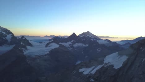 panoramic sunrise over the alps with morning light on snow covered peaks