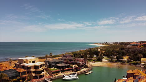 Drone's-view-of-marina-bay-residences-and-wild-nature-coastline-with-crystal-clear-water-of-indian-ocean-in-Australia