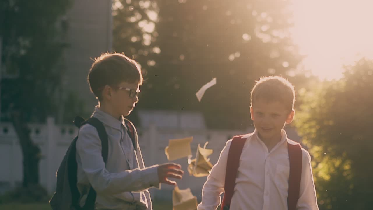 학교 소년 들 은 공원 에서 책 을 던지고 슬로우 모션 으로 다섯 개 를 던진다