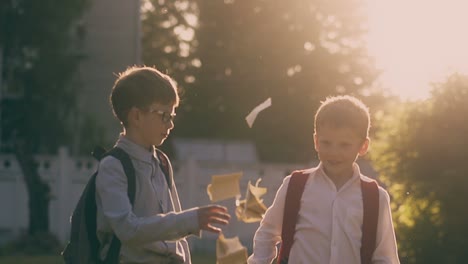 schoolboys throw books and give five in park slow motion