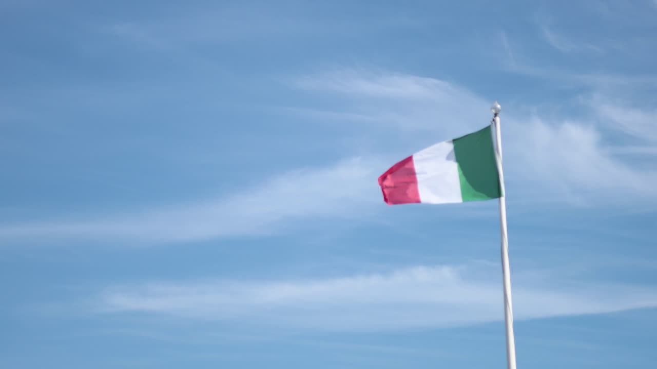 Bandiera italiana che sventola contro un cielo azzurro e limpido