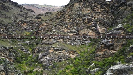 person biking at hanging bicycle track in central otago, new zealand