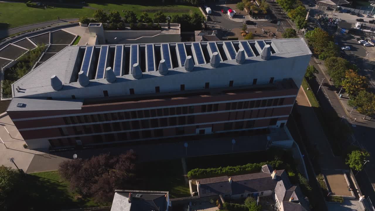 LexIcon, Dún Laoghaire, Condado de Dublin, Irlanda, Setembro de 2024. Drone orbita no sentido horário enquanto ascende sobre a icônica biblioteca e centro de patrimônio cultural com o Cais Leste ao fundo.