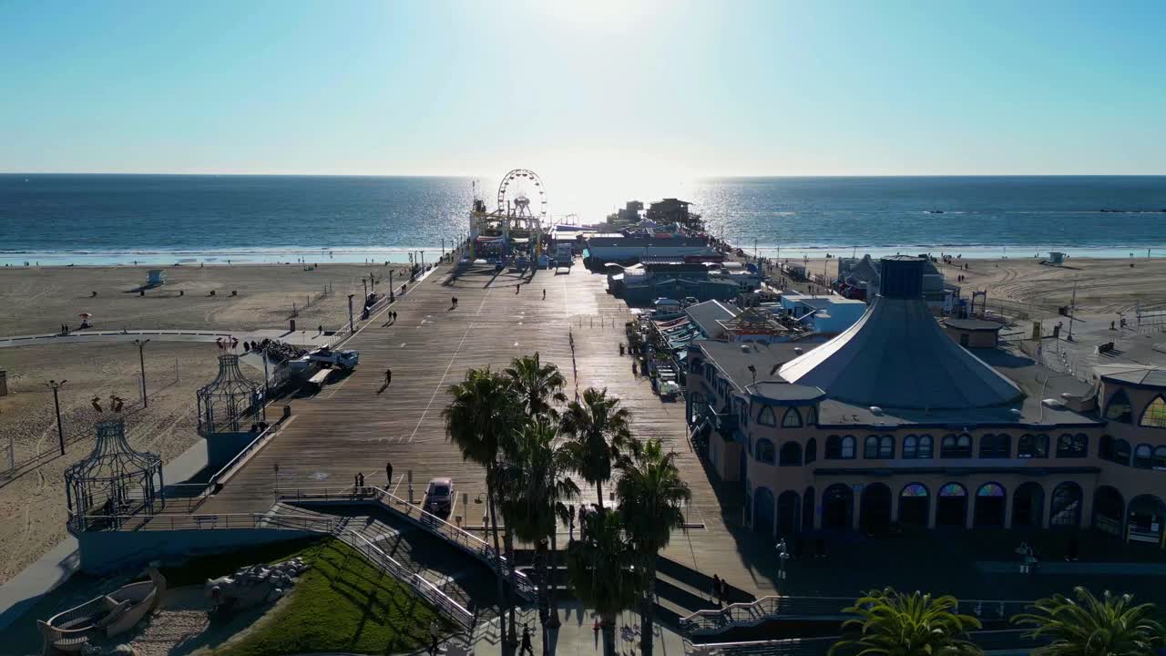 Sunlit Santa Monica Pier aerial over blue Pacific coast