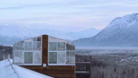 Cabaña-De-Alaska-Con-Solárium-En-El-Techo,-Panorámica-Aérea-Que-Revela-Un-Amplio-Valle-Con-Casas-En-El-Bosque