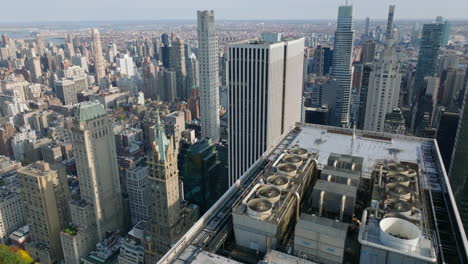 Fly-over-top-of-high-rise-building-and-tilt-down-to-streets-and-houses-bellow.-Aerial-view-of-downtown.-Manhattan,-New-York-City,-USA