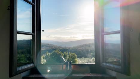 steaming warm espresso in a coffee maker on a window sill in the morning with hills in the background