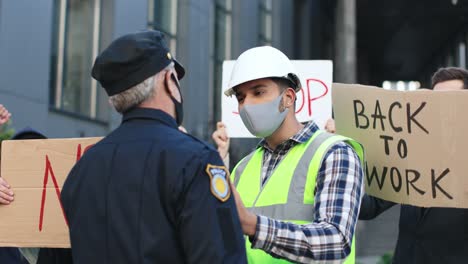 budowniczy rozmawia z policjantem w proteście przeciwko covidowi 19 na ulicy