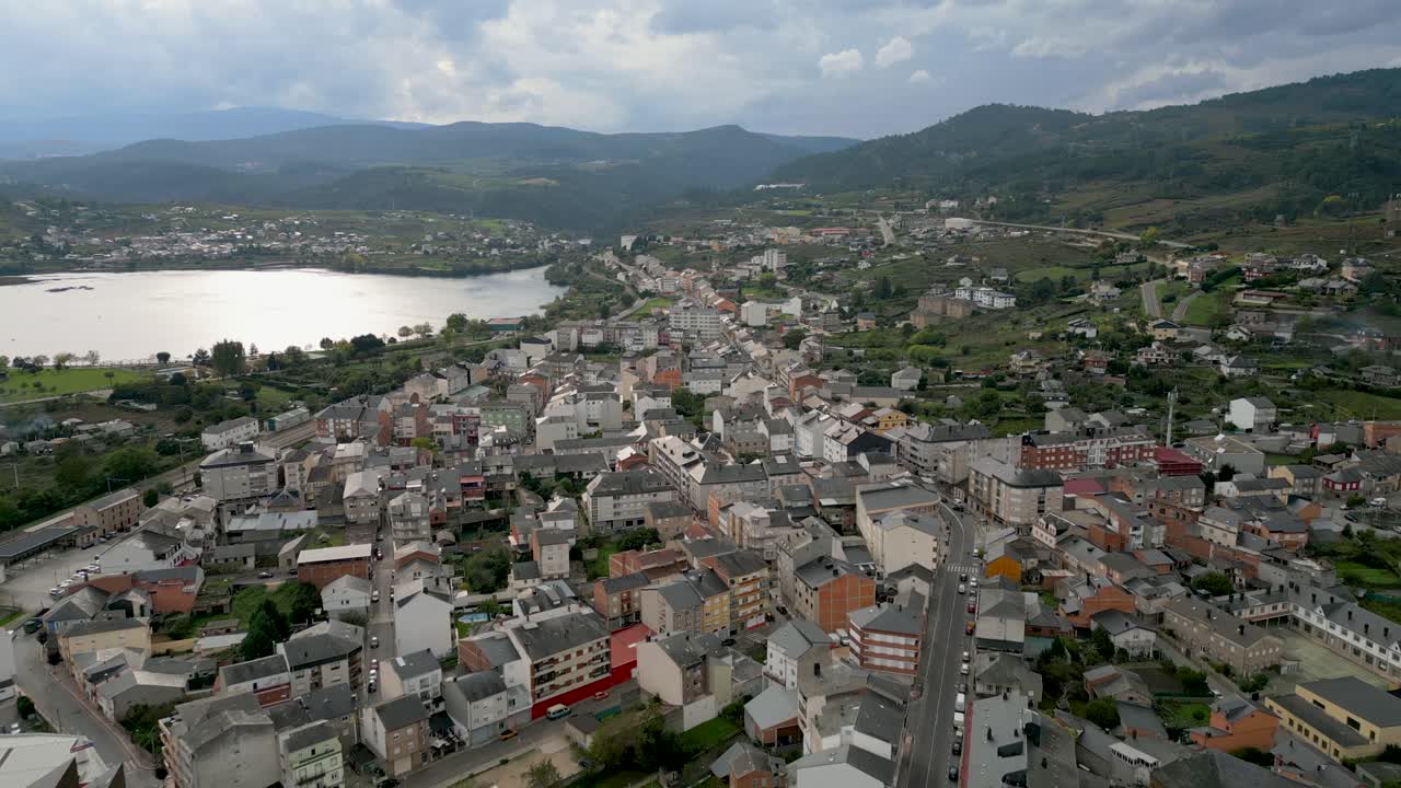High-altitude drone shot of A Rúa town, showcasing the layout of streets, buildings, and landscapes