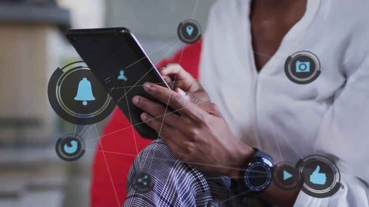 Animation of social media icons over african american businesswoman using tablet