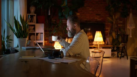 hombre trabajando desde casa por la noche