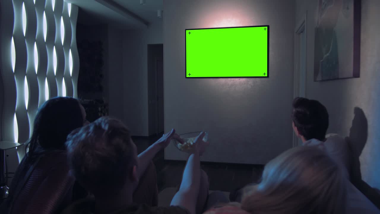 젊은 예쁜 친구 들 이 함께 텔레비전 영화 를 보고 있다