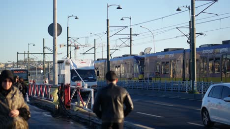 personas caminando por un puente con un tranvía y un camión