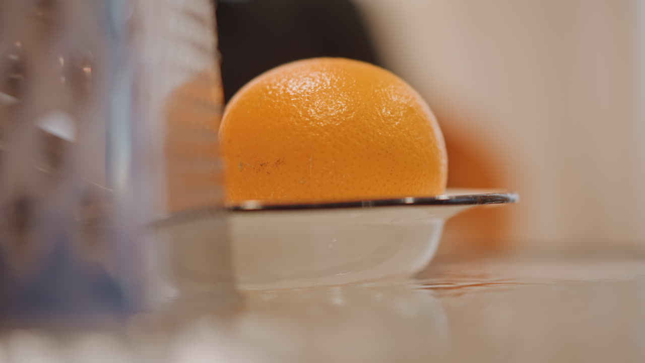 Nærbillede af dekorativ appelsinskal. Lys overflade fremhæver pynt og metalteksturer. Levende scene, der viser citruspynt med reflekterende metalaccenter og teksturerede skaldetaljer