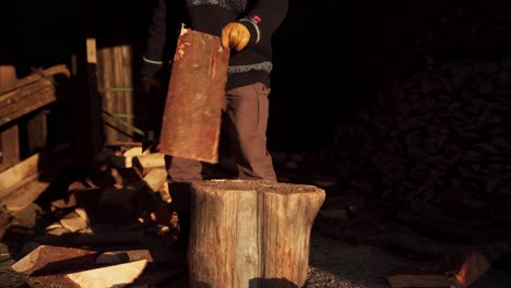 man splitting firewood in half using an axe