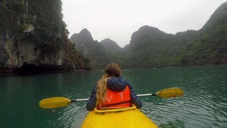 chica en kayak en el lago frente a montañas verdes