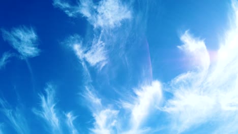 wispy clouds moving across a blue sky