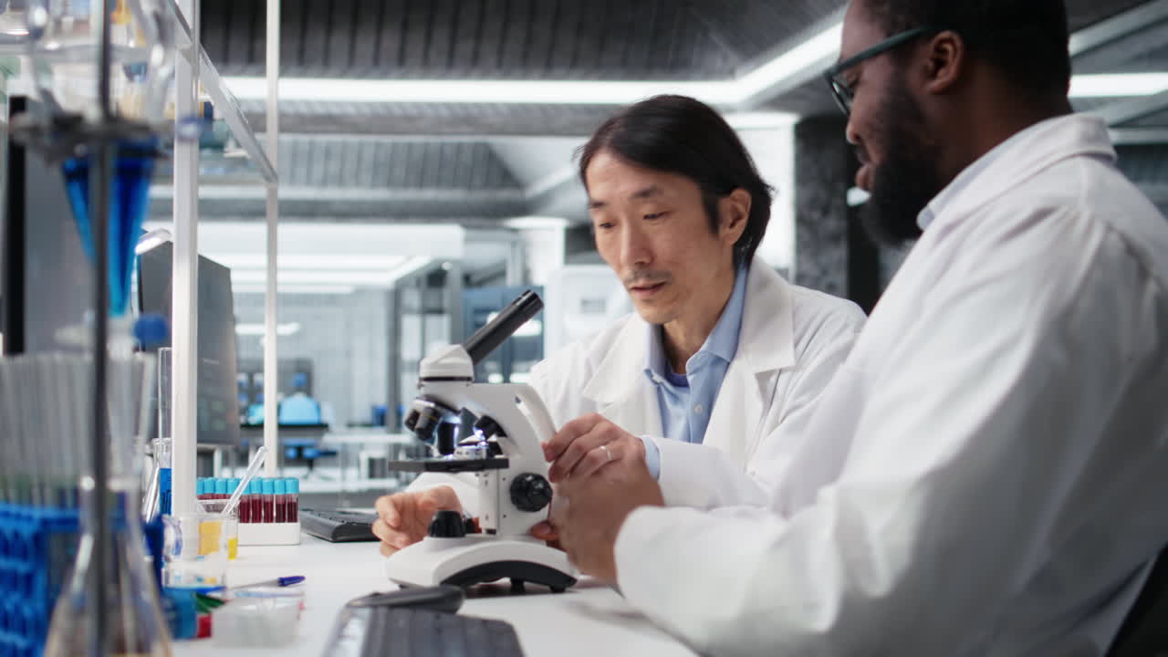 Vertical video Team of multiethnic researchers using microscope