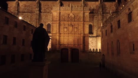 historical neoclassical facade filled with engravings illuminated at night in salamanca, spain