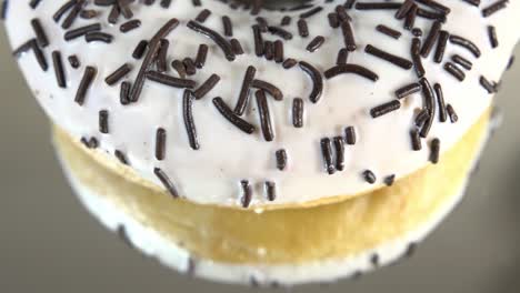 rotating donuts with different fillings on the mirror table. delicious sweet donut rotating on a plate. bright and colorful donut close-up macro shot spinning on a white background. seamless loop.