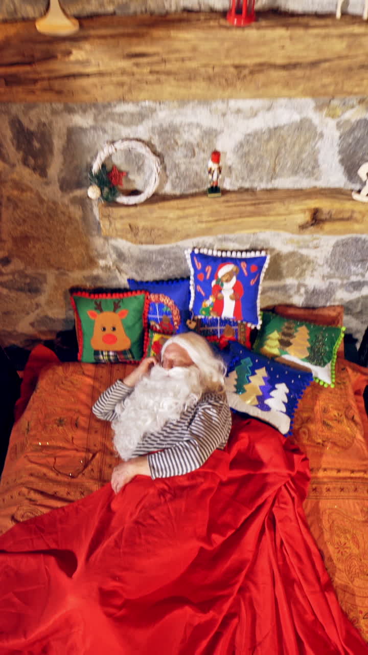 Santa Claus is sleeping in specially decorated room in his bed. He is holding his hand under his cheek. Christmas spirit concept close up video. Vertical video