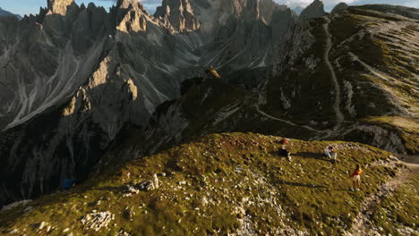 drone disparó sobre la gente en una cresta de la montaña revelando las torres de mordor, noche soleada en los dolomitas, italia