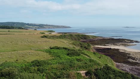 Traeth-Lligwy-Anglesey-eroded-coastal-aerial-view-over-scenic-green-Welsh-weathered-cliff-coastline