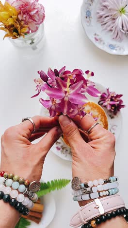 woman's hands holding flowers over pancakes