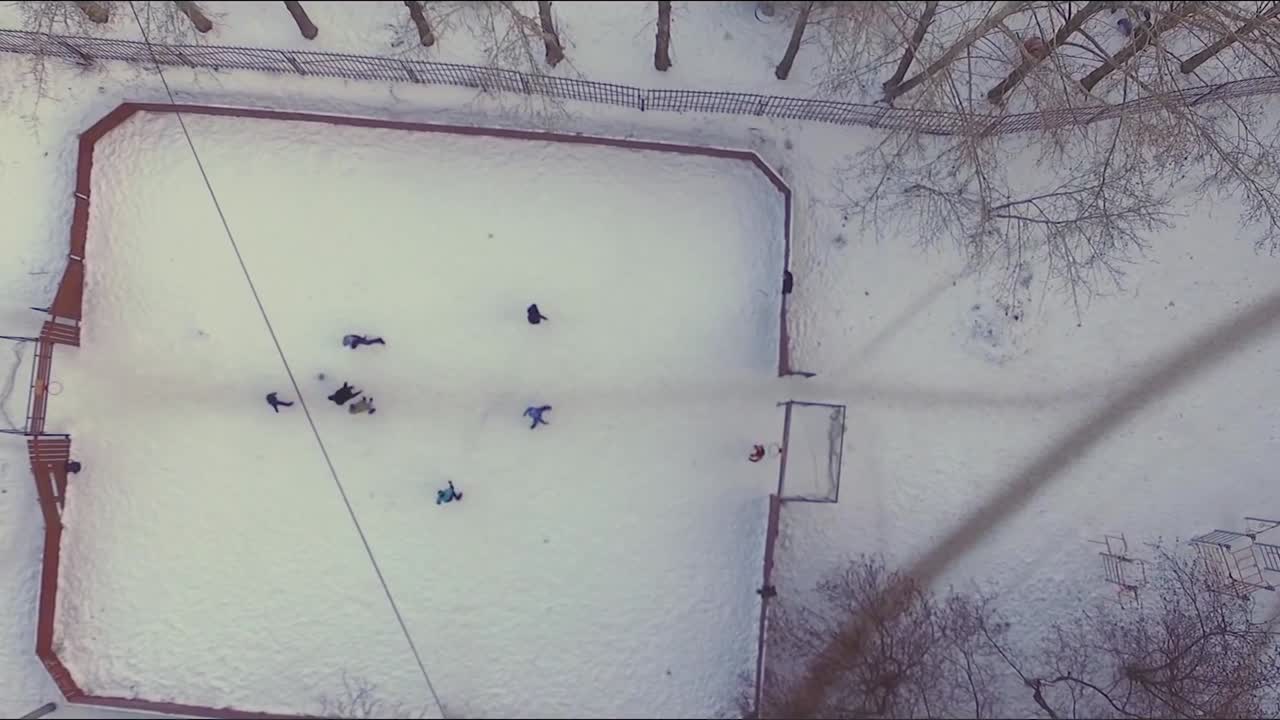 niños jugando al hockey sobre hielo en un patio de recreo nevado