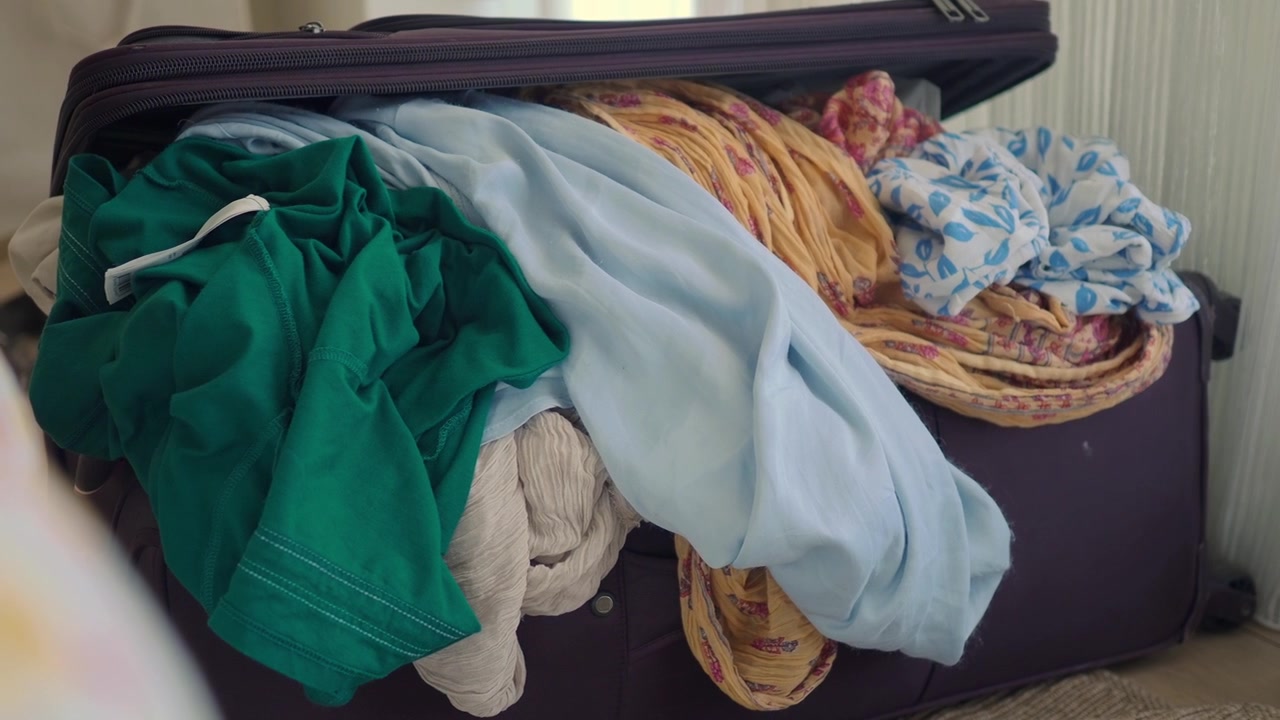 Open Suitcase Filled With Messy Clothes