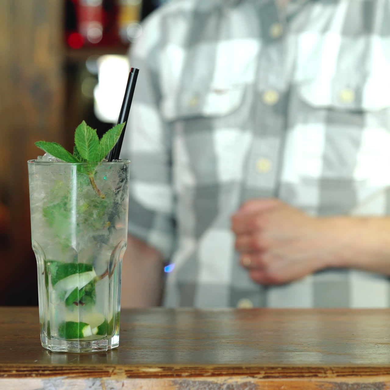 Baarimikko valmistaa raikasta, kylmää cocktailia baaritiskillä. Uskomaton sekoitus. Neliövideo