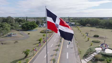 Aerial-orbiting-shot-of-Military-SAN-ISIDRO-AIR-BASE-with-waving-flag-of-Dominican-Republic-during-sunny-day