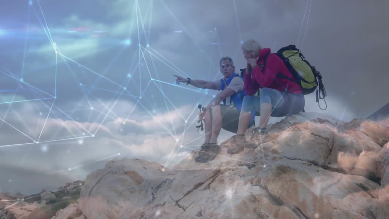 Una coppia raggiunge la cima, aggiusta l'attrezzatura, indica l'orizzonte e osserva la formazione di una rete tecnologica digitale.