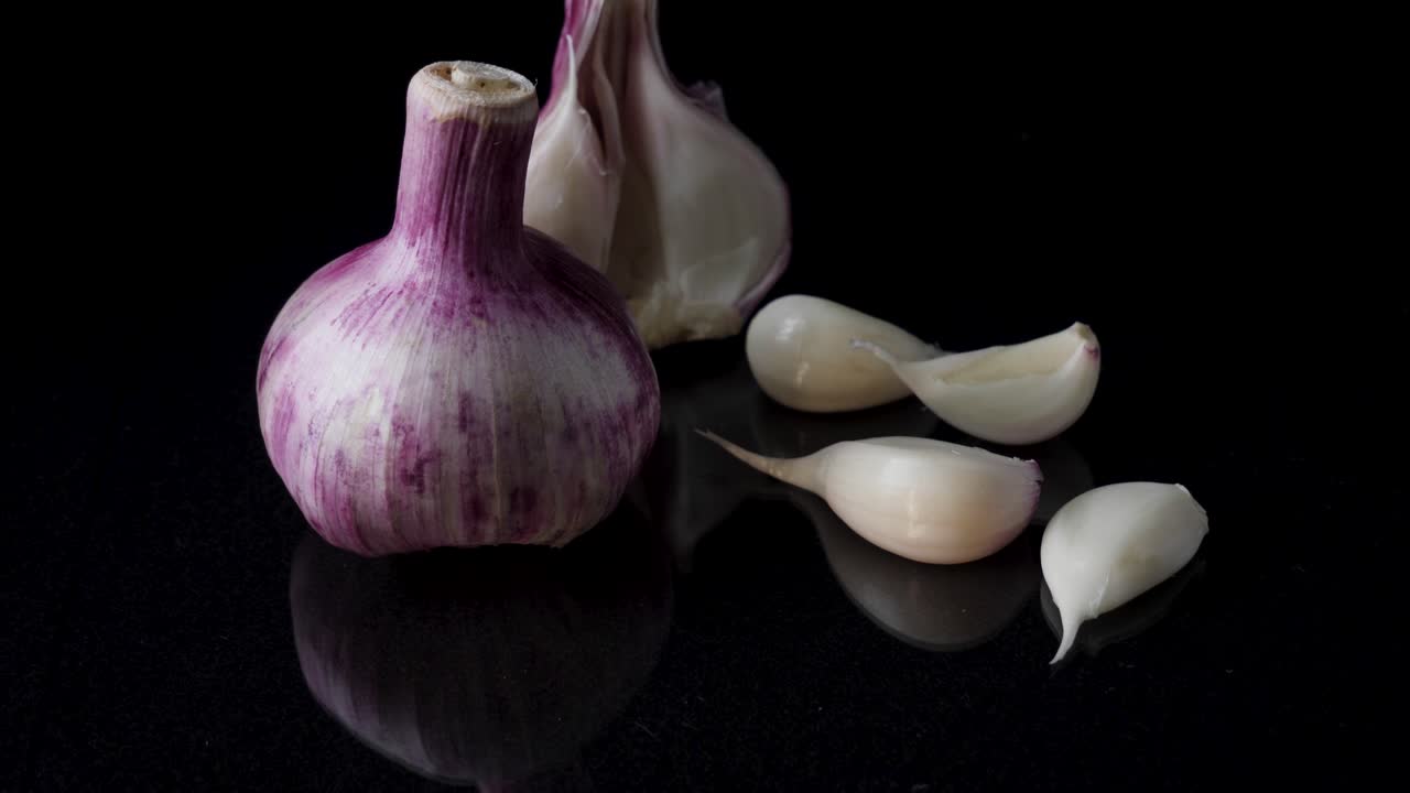 Close-up of a garlic bulb with cloves on a black surface