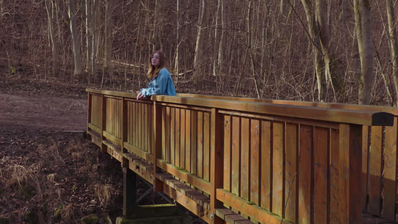 Girl walking over a wooden Bridge in a Forrest