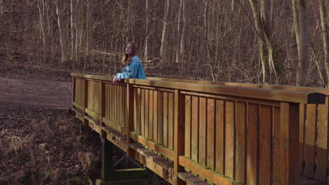 girl walking over a wooden bridge in a forrest